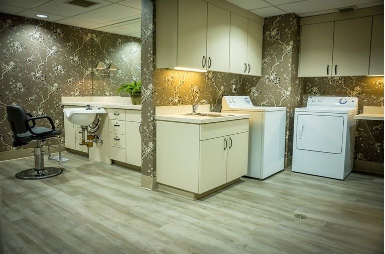 A modern laundry room with a washer, dryer, and ample cabinet space.