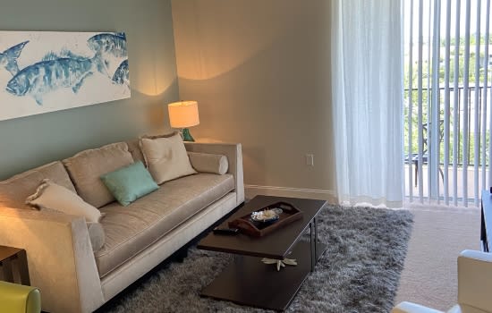 A cozy living room with a sofa, decorative pillows, a lamp, and a coffee table.