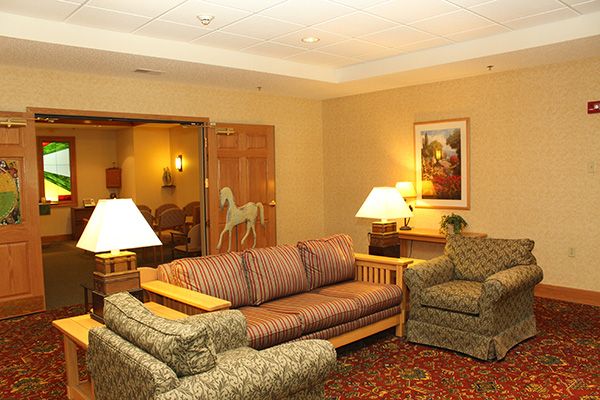 A cozy living room with a sofa, armchairs, and warm lighting.