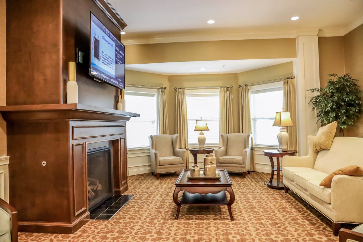 A cozy living room with a fireplace, television, and comfortable seating arrangements.