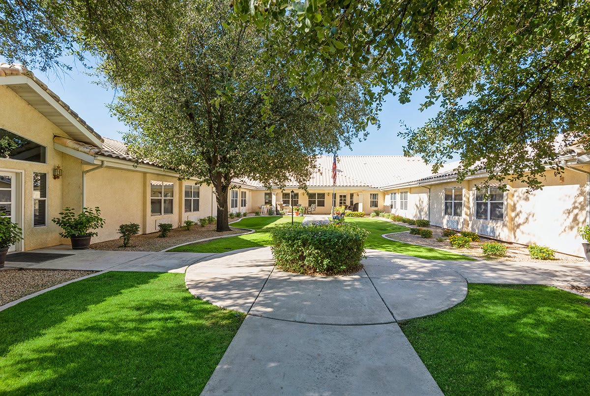 A scenic courtyard with a circular walkway surrounded by buildings and lush greenery.