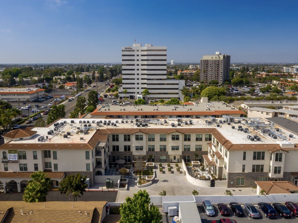 An aerial view of a residential building surrounded by urban infrastructure and cityscape.