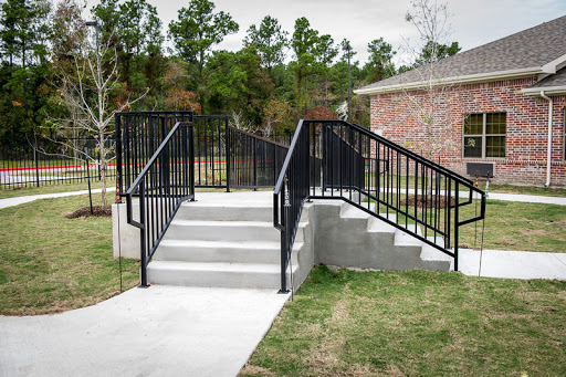 A wheelchair-accessible ramp with handrails leading to a set of stairs.