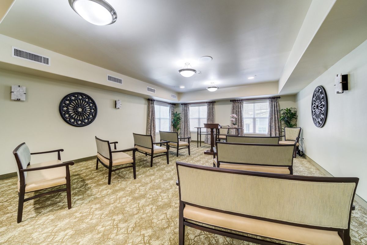 An interior view of an empty meeting room with chairs arranged in rows.