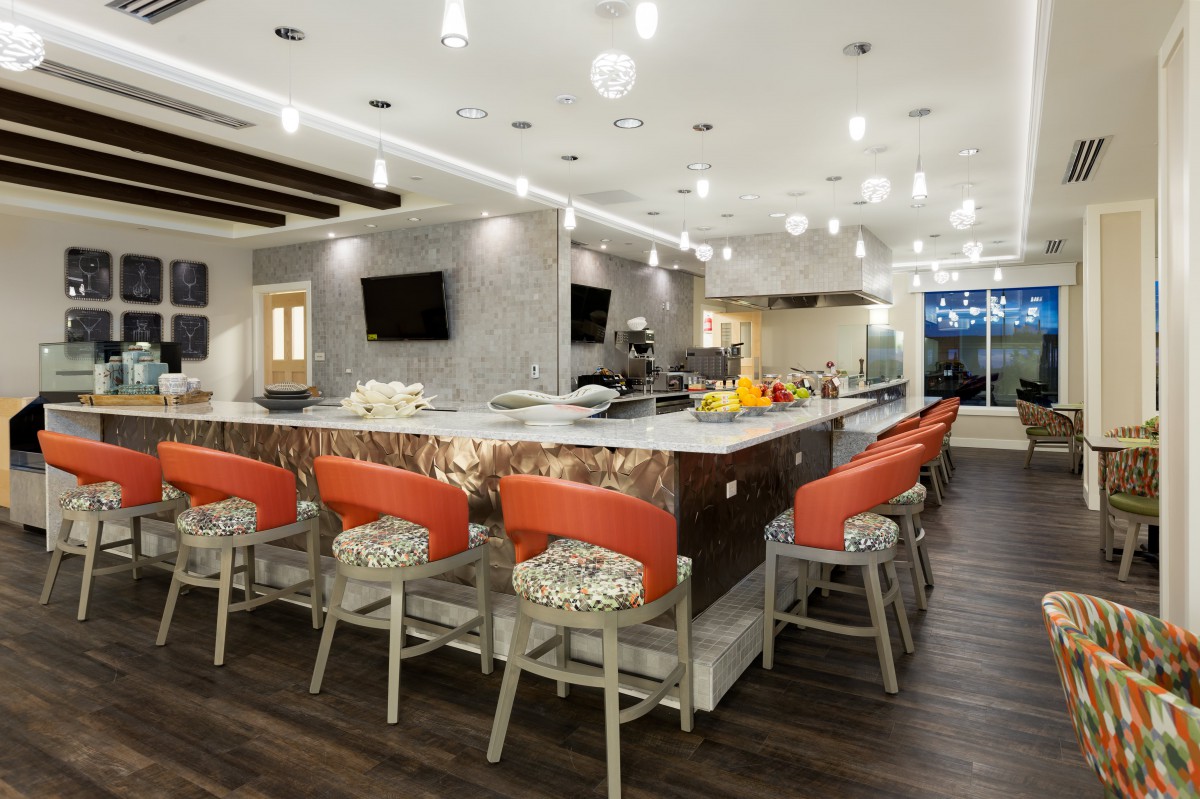 A spacious and modern kitchen with bar seating and stylish lighting.