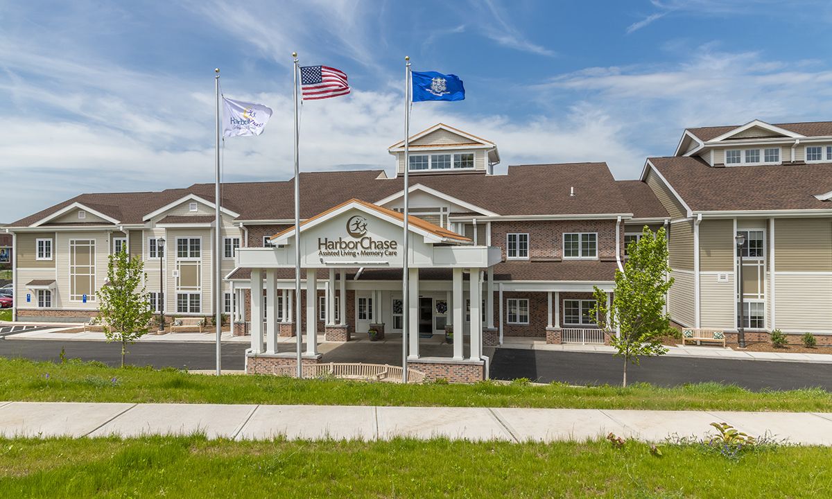 A hotel building with multiple flags at the entrance.