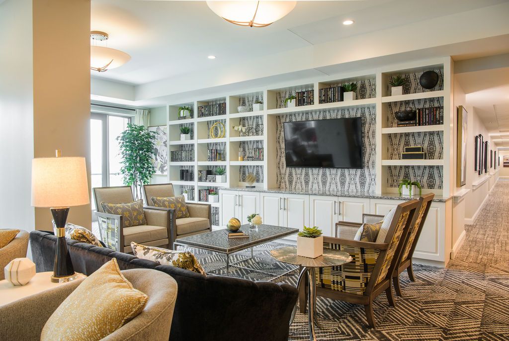 A modern living room with built-in bookshelves, a large TV, and comfortable seating.