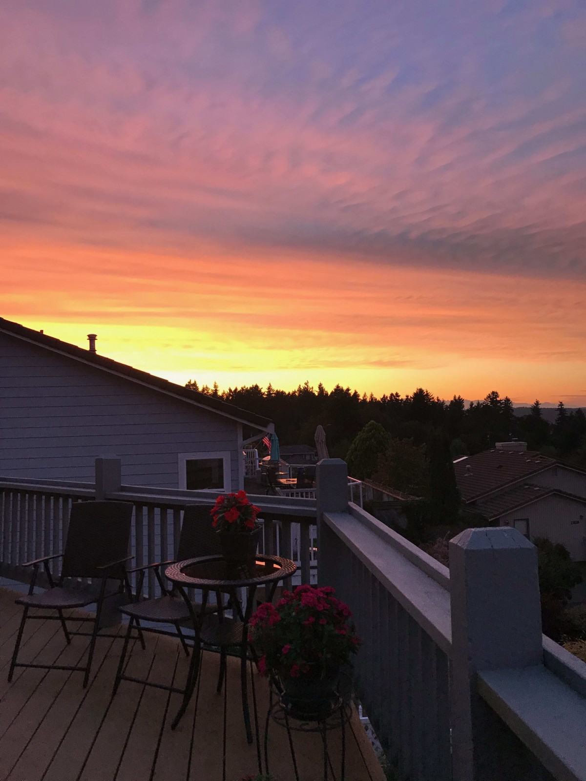 A beautiful sunset view from a deck overlooking a residential area.