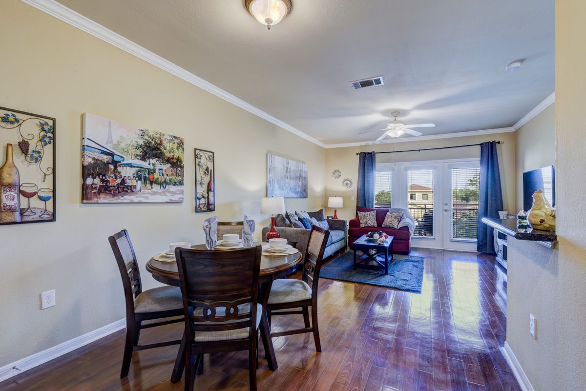 A cozy living room with a connected dining area, featuring hardwood floors and elegant decor.