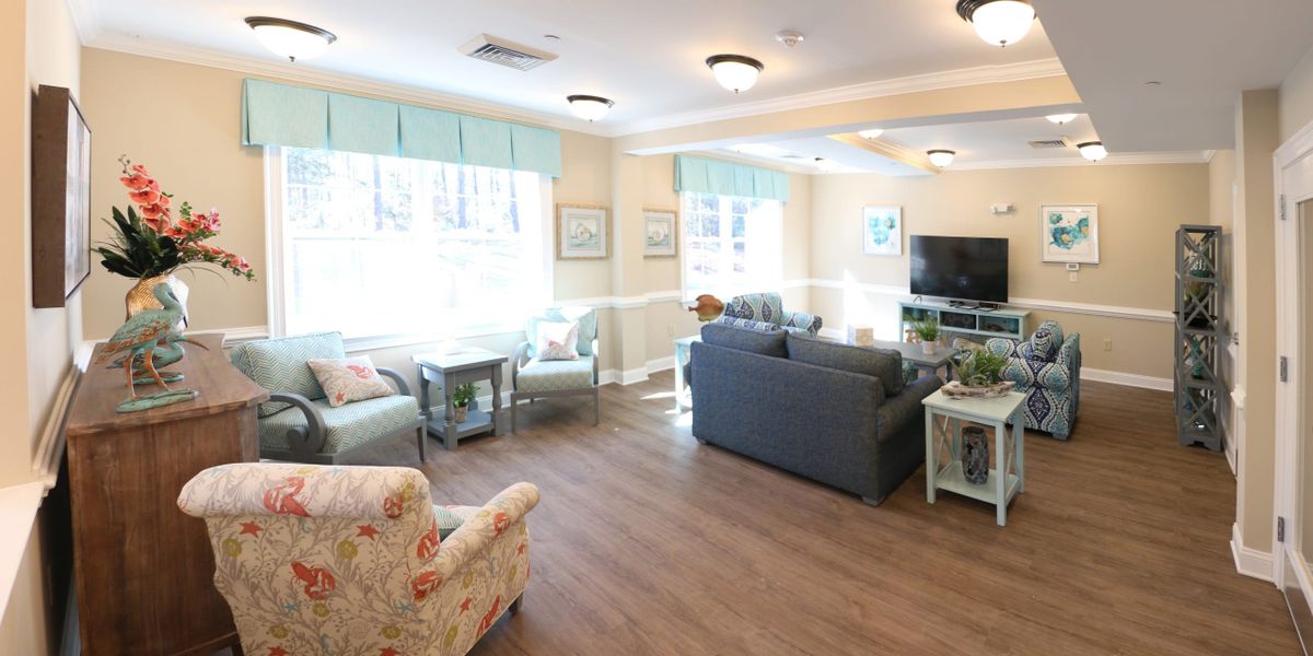 A cozy and bright living room with comfortable seating and a television.