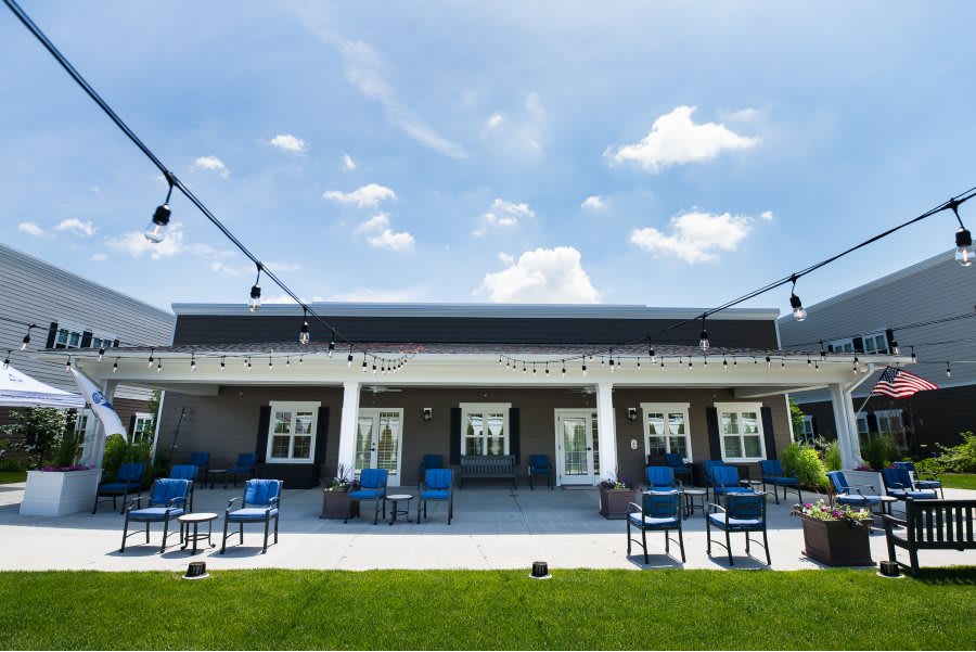 A modern outdoor patio with seating arrangements under a clear blue sky.