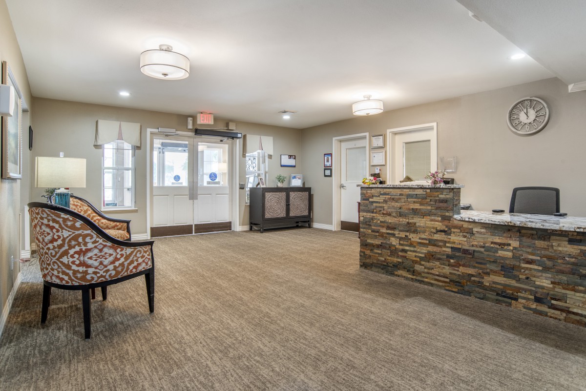A modern reception area featuring a stone desk and comfortable seating.