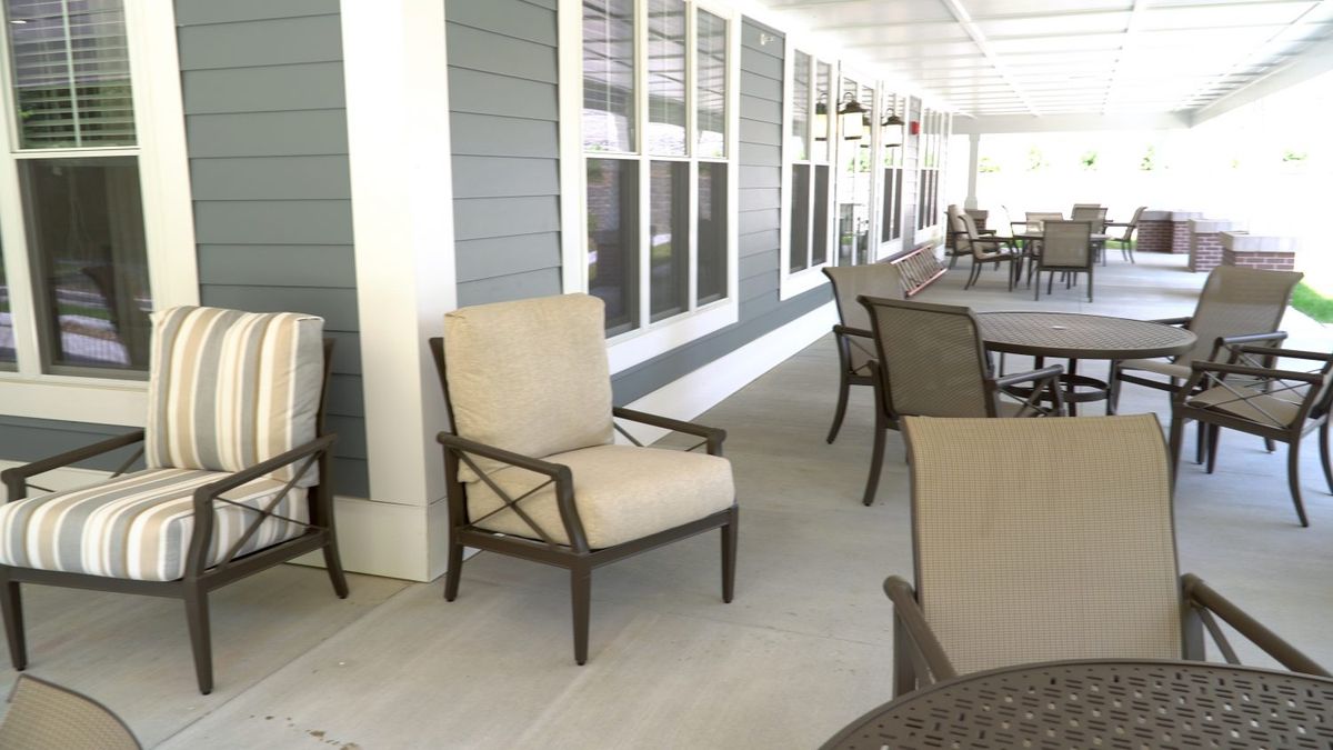 Outdoor patio area with comfortable seating and a row of windows.