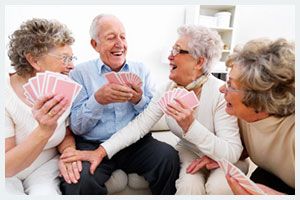 A group of seniors enjoying a lively game of cards together.