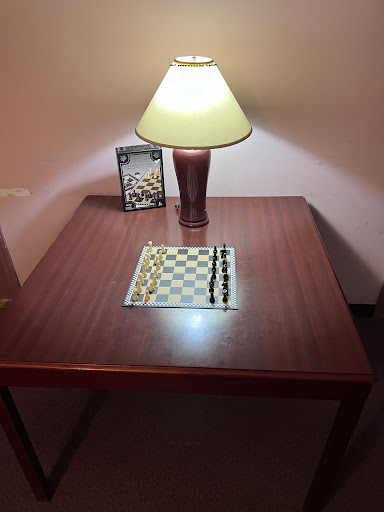 A cozy setup featuring a chessboard and a lamp on a wooden table.