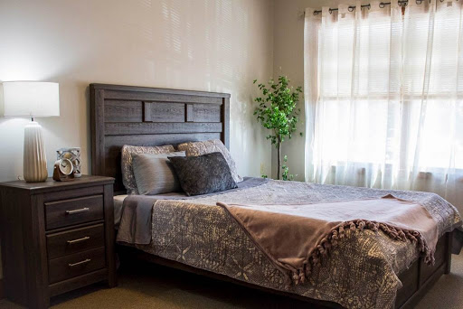 A cozy bedroom featuring a stylish bed with decorative pillows and a bedside table.
