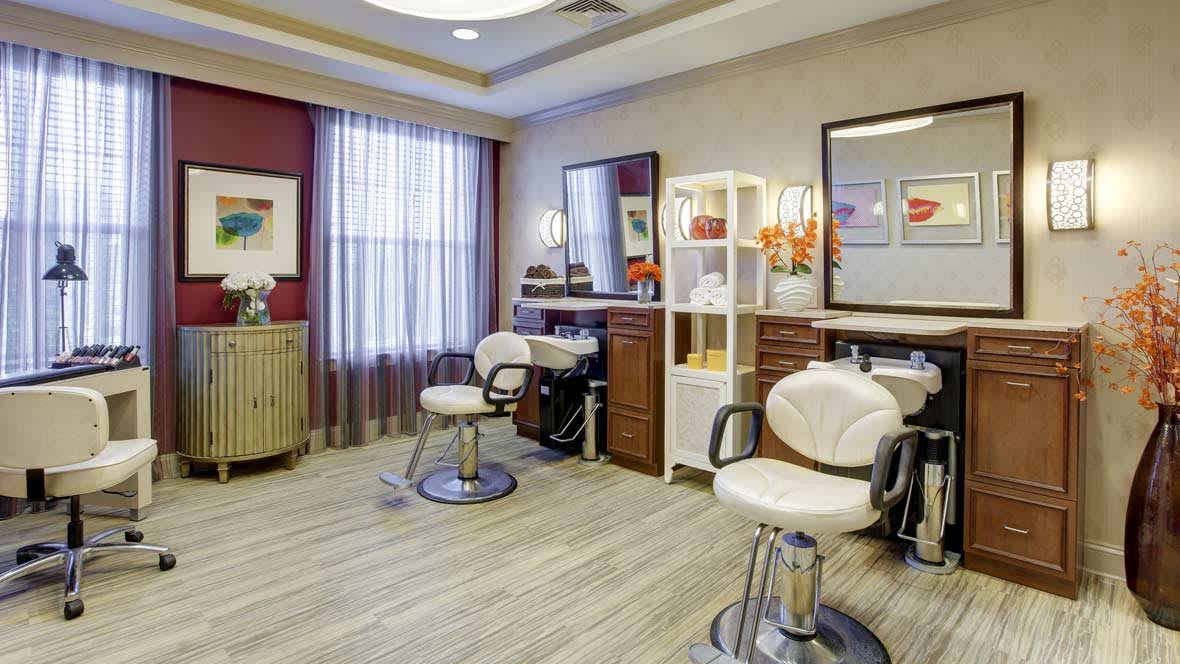 A modern beauty salon with chairs and mirrors, ready for customers.