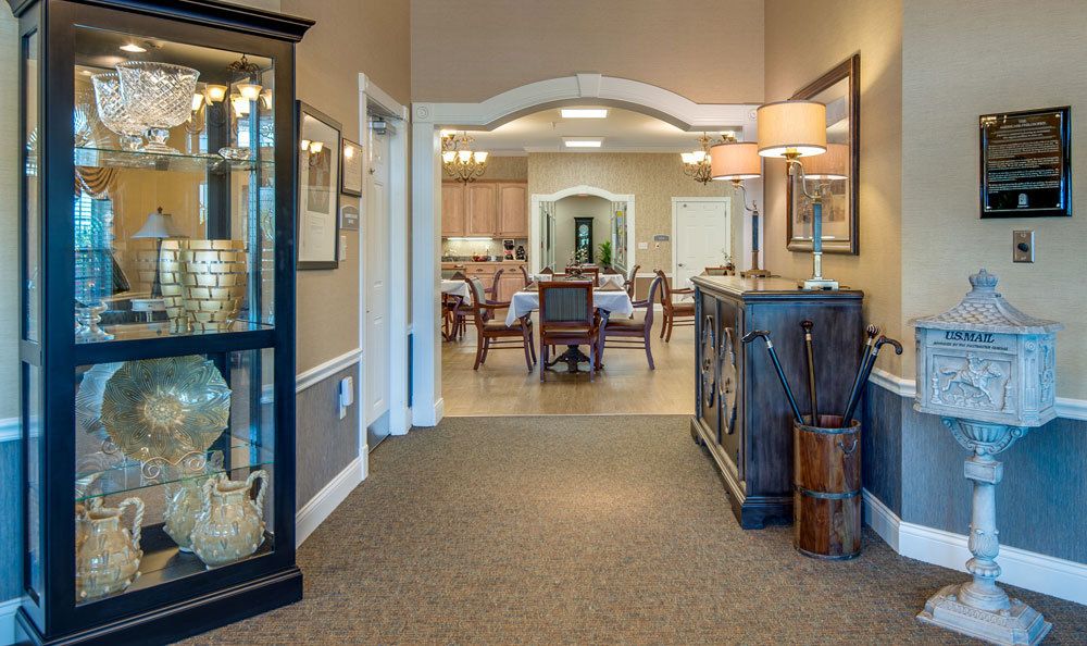 A hallway leading to a cozy dining area, adorned with elegant furniture and warm lighting.