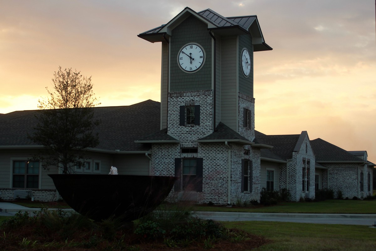 A clock tower stands tall against the backdrop of a colorful sunset.