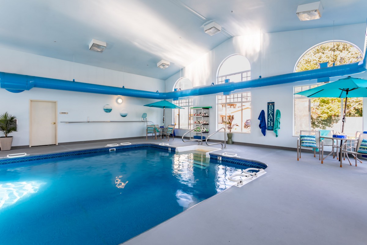 An indoor swimming pool with bright lighting and recreational amenities.