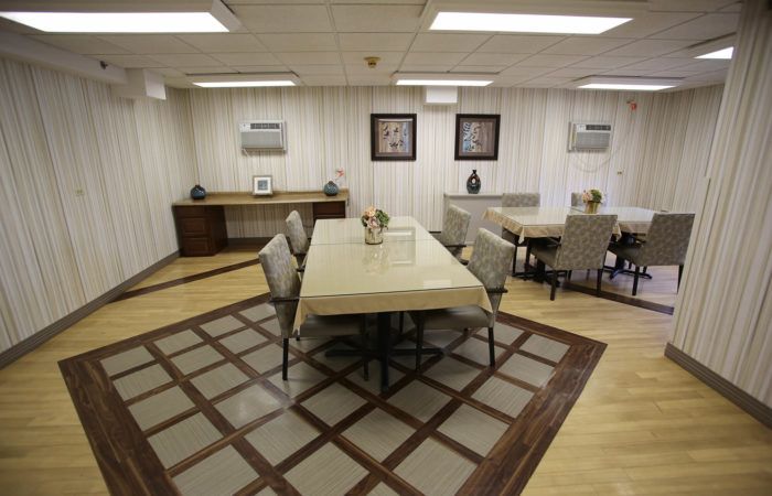 A well-arranged dining room with a large table and chairs on a patterned carpet.