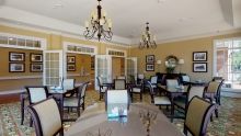 A well-decorated dining room with chandeliers and neatly arranged tables and chairs.