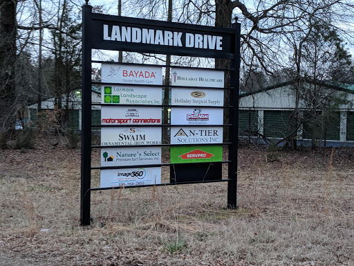Business directory sign for Landmark Drive displaying various companies.