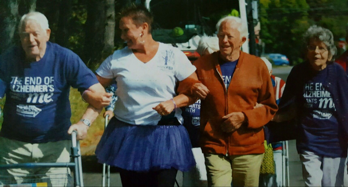 A group of people walking together at an outdoor event, one wearing a tutu.