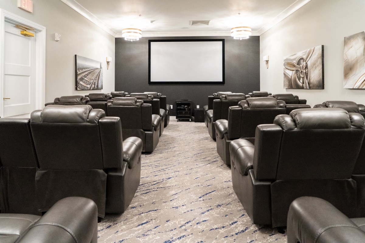 A luxurious home theater with recliner seating and a large projector screen.