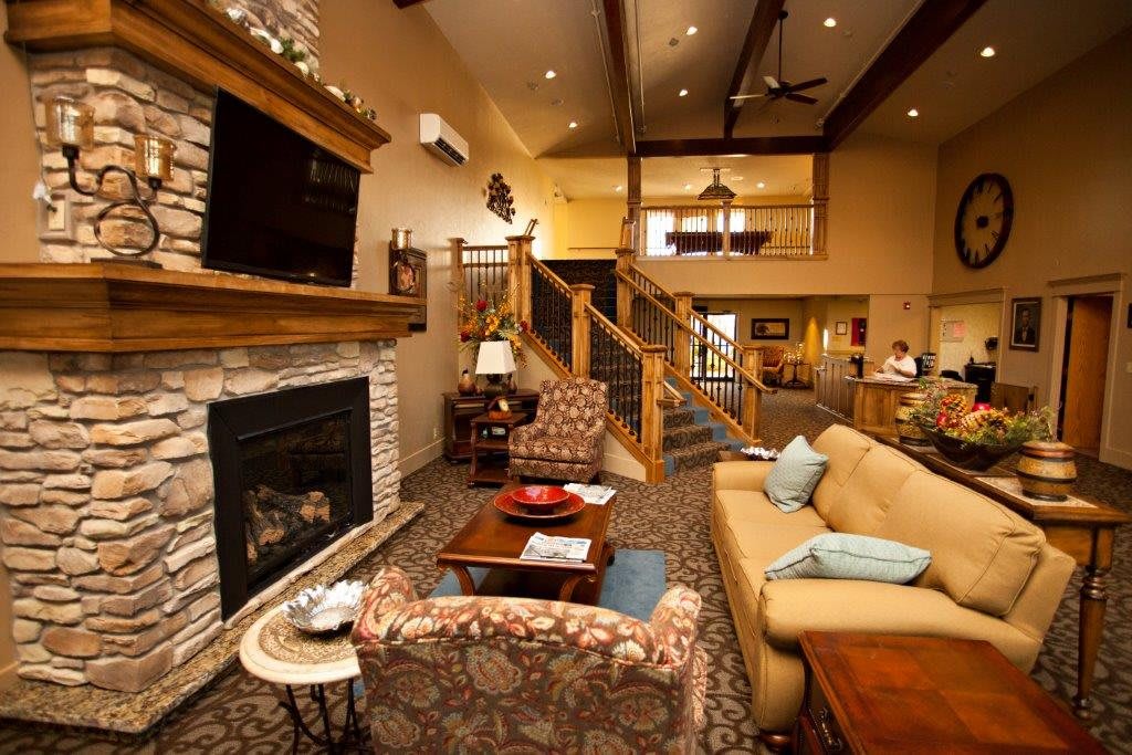 A cozy living room with a fireplace and comfortable furniture in an open, warmly-lit space.