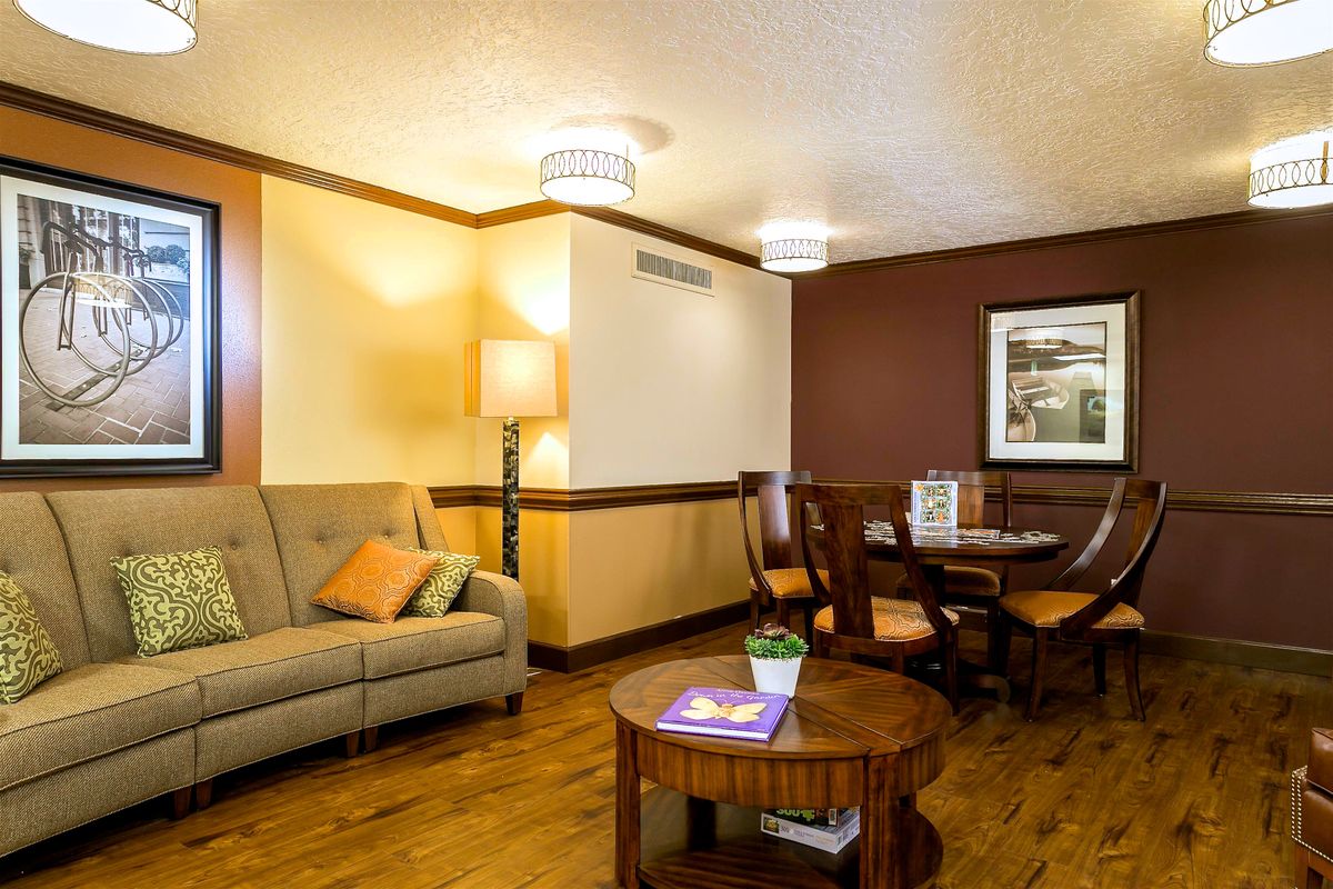A comfortable living room with a sofa, dining table, and warm lighting.