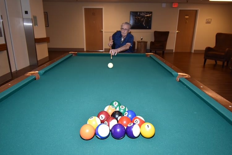 A person preparing to break in a game of billiards on a pool table.