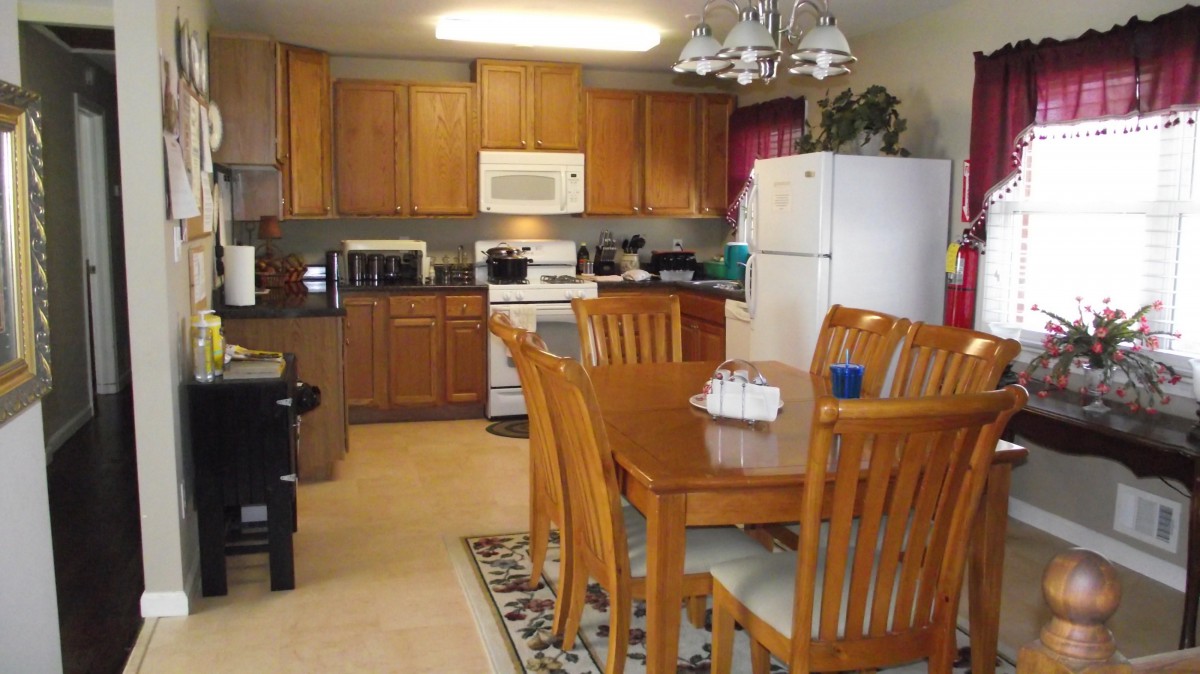 A cozy kitchen with wooden cabinets and a dining area featuring a wooden table and chairs.