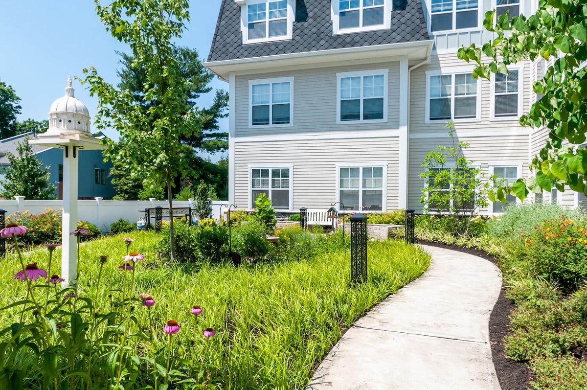 A residential building with a landscaped garden and a curved pathway.