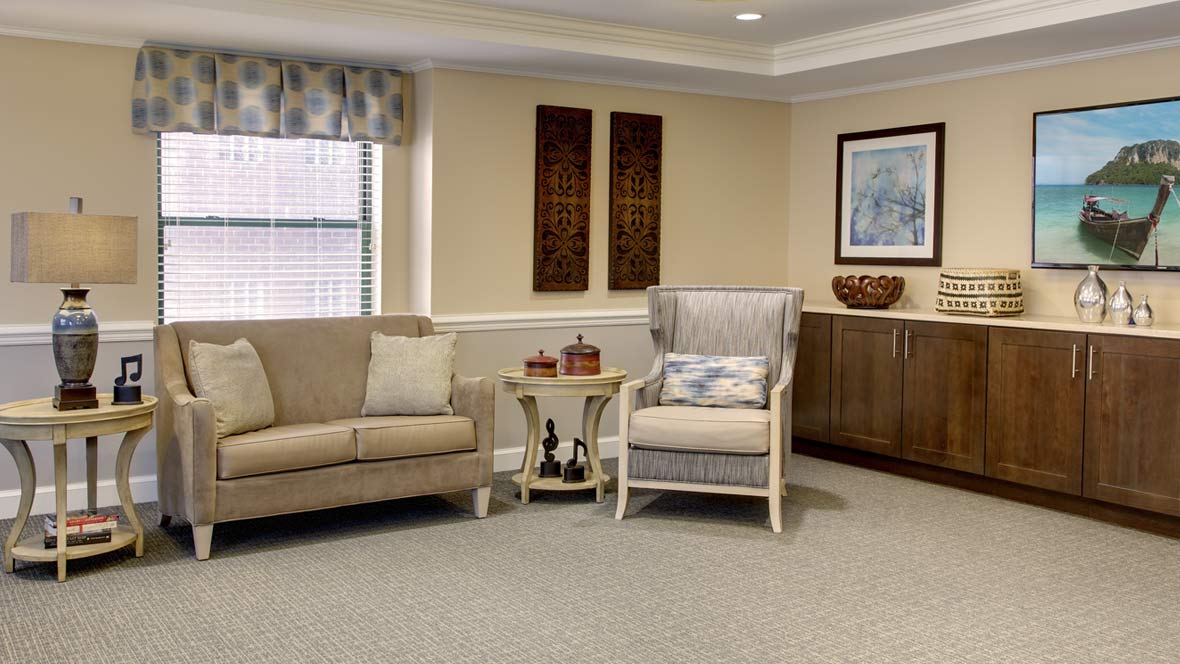 A cozy living room with a sofa, armchair, and decorative elements.