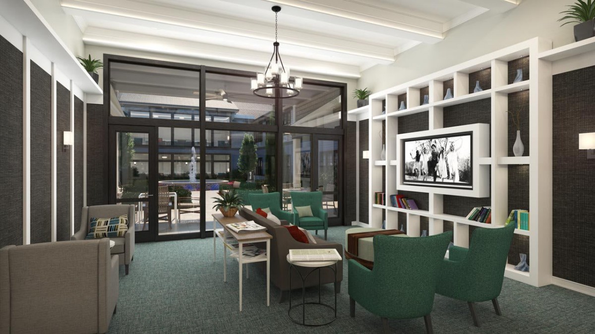 A modern living room featuring a large bookshelf, comfortable seating, and glass doors leading to an outdoor area.