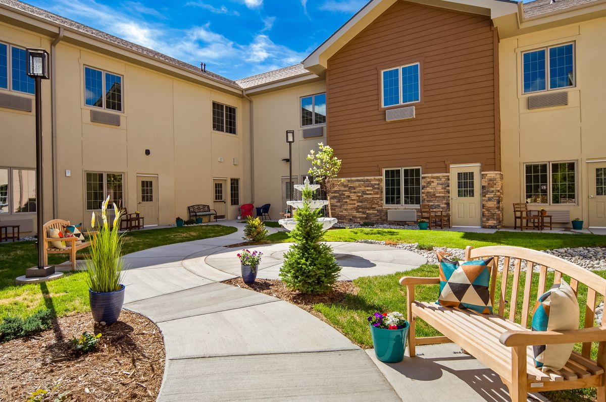 A serene courtyard with a fountain, surrounded by a landscaped garden and seating areas.