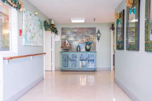 A well-decorated hallway featuring a reception area with decorative furniture and plants.