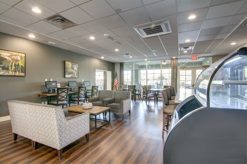 Modern cafe interior with comfortable seating and large windows.