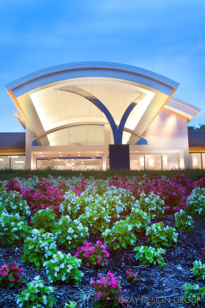 Modern architectural building entrance with vibrant flower landscaping.