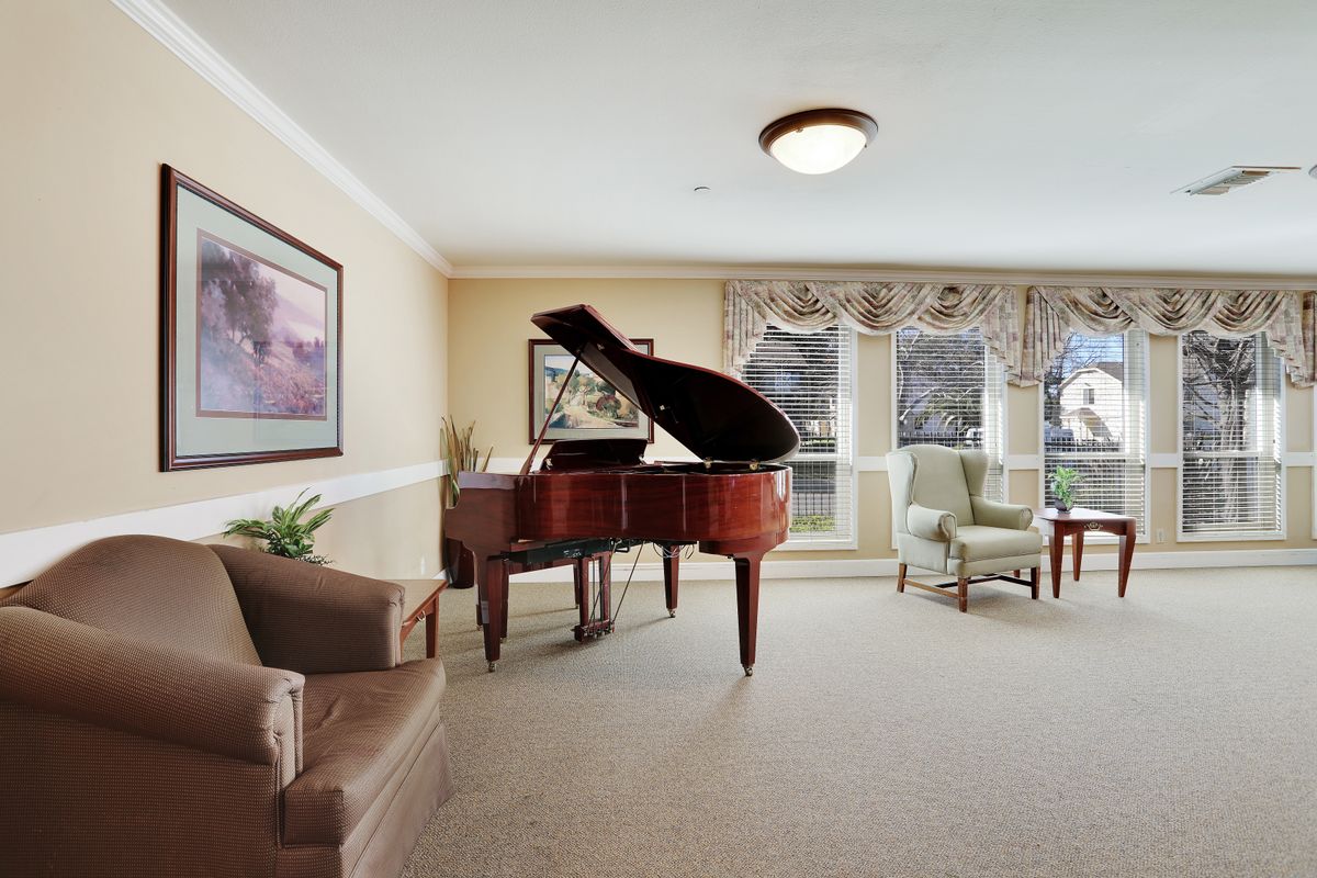 A cozy living room with a grand piano and comfortable seating.