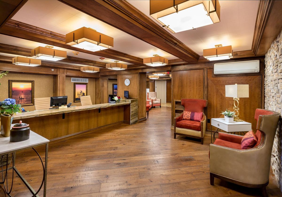 A warmly lit reception area with wooden interiors and comfortable seating.