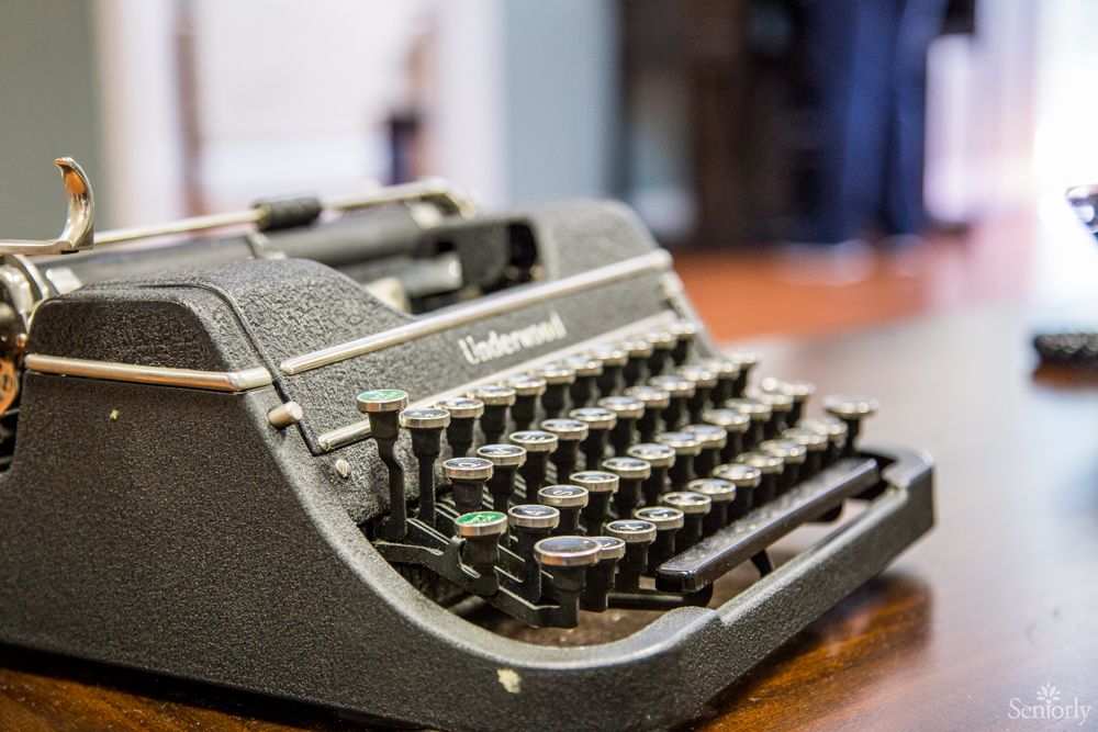 A vintage typewriter on a wooden table, showcasing its classic design.