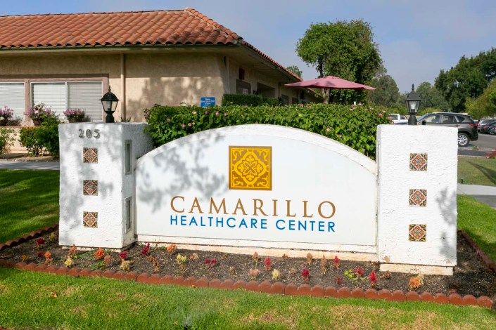 A sign for Camarillo Healthcare Center outside a building.