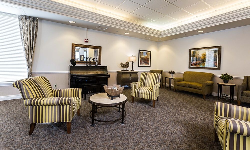 A cozy living room with striped chairs, a sofa, and decorative elements.