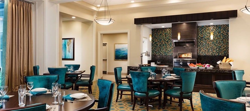 A modern restaurant dining room with teal chairs and elegant decor.