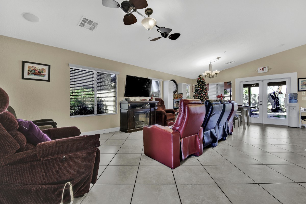 A spacious living room with recliners, a television, and modern decor.