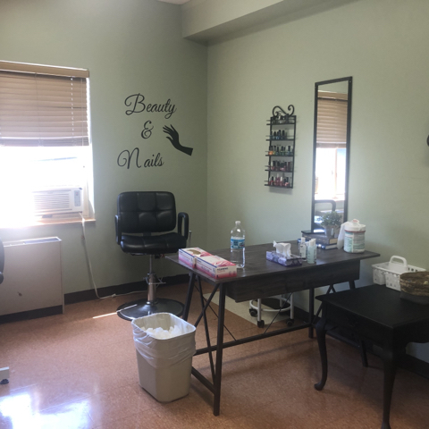 A cozy beauty salon treatment area featuring a mirror, styling chair, and various tools.