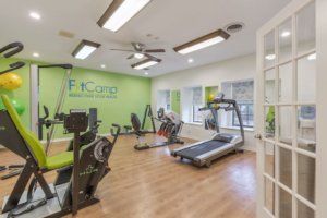 A well-lit fitness center with exercise equipment including a treadmill and stationary bikes.