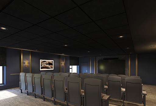 A modern cinema room with sleek black seating and ambient lighting.